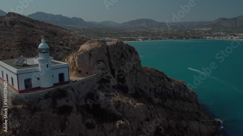 Serene lighthouse with solar panels on coastal cliff, Spain