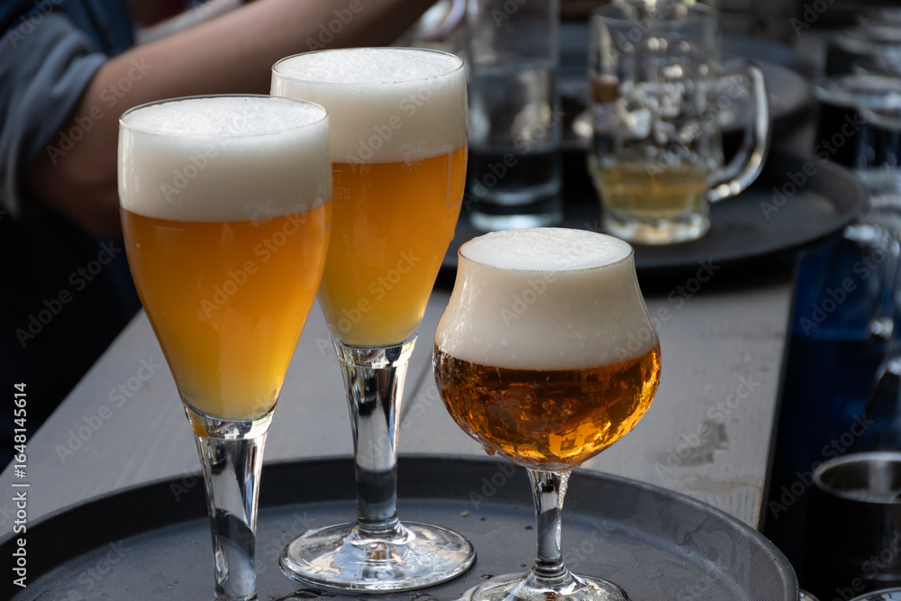 Fototapeta premium Belgian beer in glass in old brewery in Bruges, strong triple, tasty beverage, lunch with beer, tourist destination, Flanders, Belgium