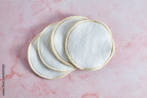 Reusable makeup remover pads resting on pink marble countertop