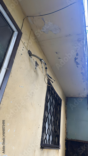 Old house facade with wires and peeling plaster