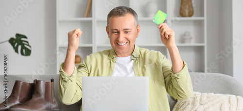Happy mature man with lapto...