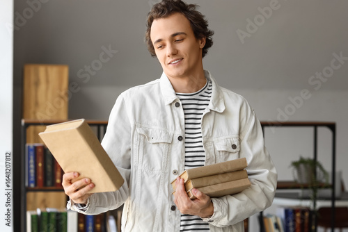 Young man with books in library