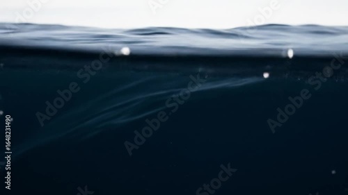 Captivating Ocean Surface: Dark Blue Sea Water with Gentle Waves and Sparkling Highlights