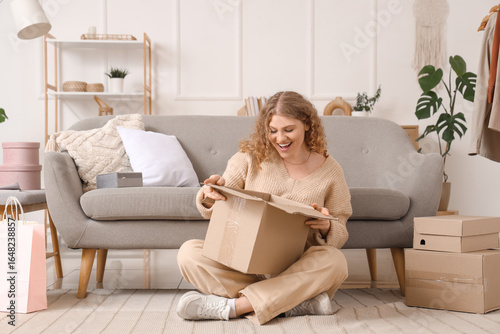 Happy young woman unpacking...
