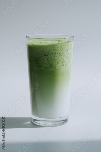 High-resolution photo of a glass of matcha latte with frothy milk, isolated on a clean background, showcasing vibrant green color and creamy texture