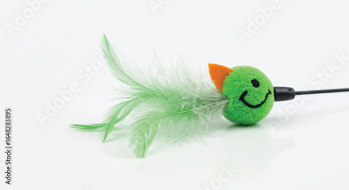 Green smiling bird cat toy with feathers on white background