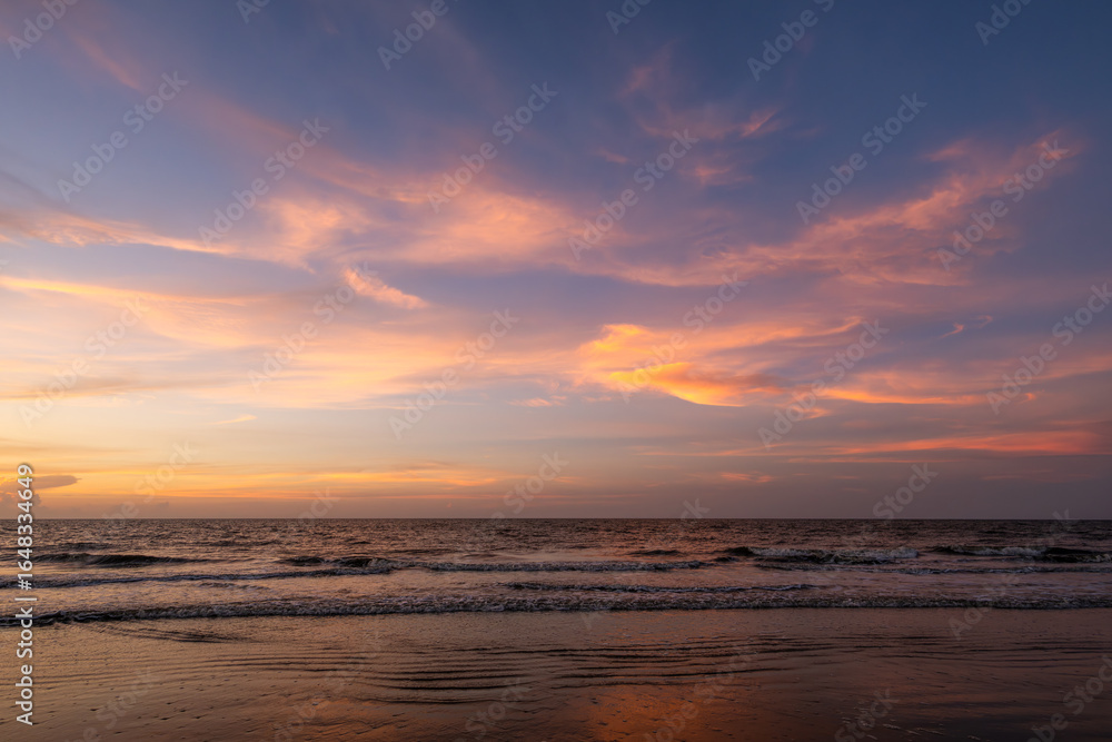 Beautiful sunset over the ocean with vibrant colors illuminating the sky at the beach Beautiful sunset over the ocean with vibrant colors illuminating the sky at the beach