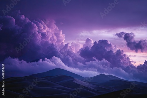 Dramatic purple clouds over dark dunes at sunset