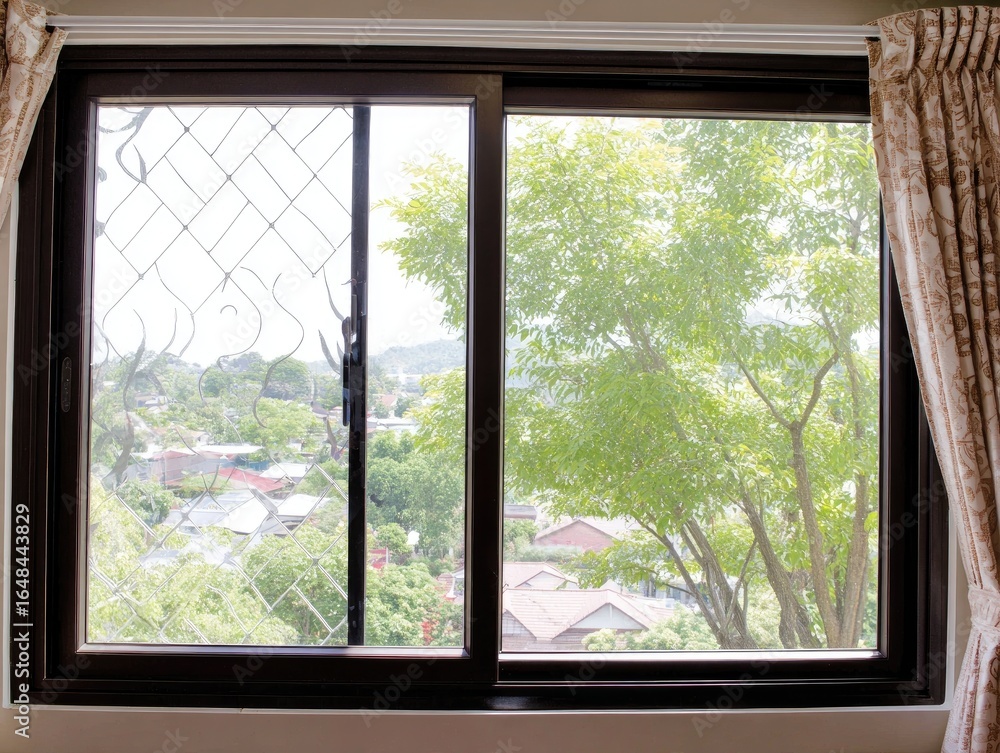 Naklejka premium Interior view of a window with a city and tree view