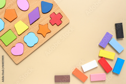 Wood Geometric Shapes with colorful wooden blocks. Set of different children's toys on beige background from above.
