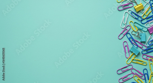 Colorful paperclips arrangement on teal background