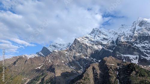 Canvas Print panoramic view of snow filled mountains with texture and clouds in the bright bl