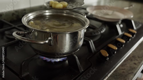 collecting ready gnocchi from a pot