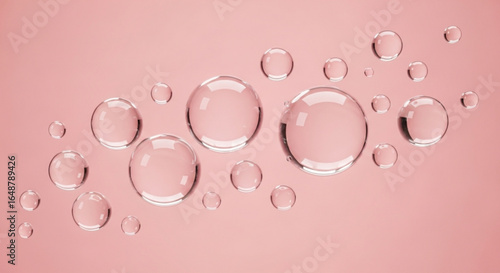 Clear water drops on pink background for hydration skin care beauty product cosmetic serum essence concept