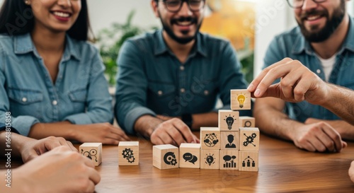 People building a pyramid of wooden blocks with business icons on a table.