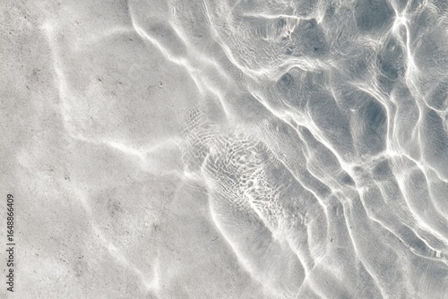 Abstract water surface texture, light reflecting on gray-white sand