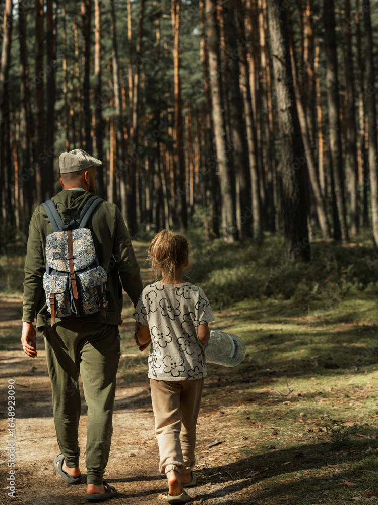 Fototapeta premium father and daughter walking in the forest