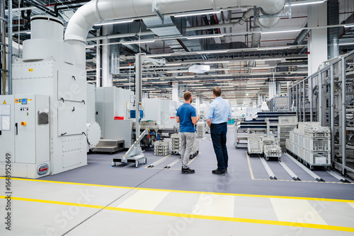 Wallpaper Mural Rear view of businessman and employee standing in a factory Torontodigital.ca