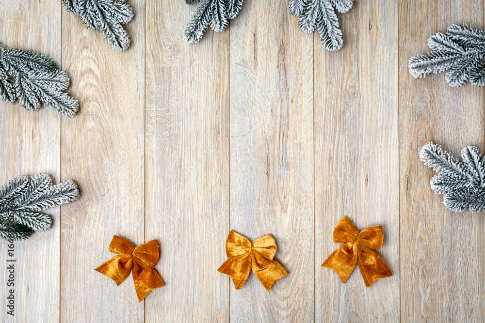 Fototapeta premium Snowy Christmas fir branches, sparkling ornaments, and festive gift on cozy rustic wooden table
