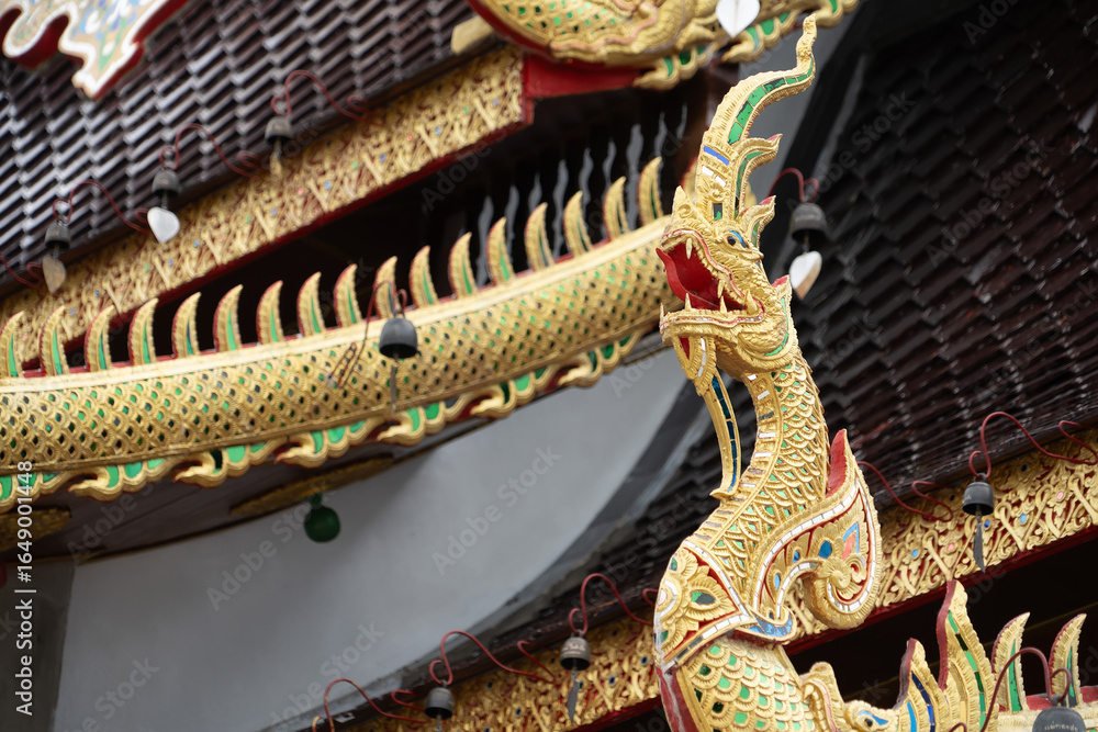 Obraz premium Chiang Mai, Thailand - July, 18, 2025 :Colorful ornate dragon sculpture on temple rooftop with intricate details in traditional Thai architectural style at Chiang Mai, Thailand.