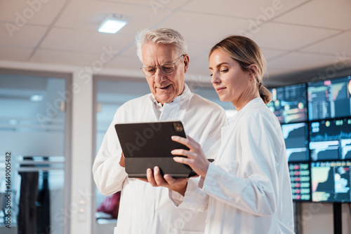 Medical professionals collaborating on tablet in modern clinic