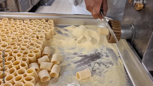 Hands Preparing Fresh Pasta with an Extruder in a Food Production Setup