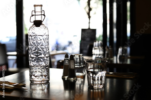 A view of some glasses and a water bottle on the table of a Parisian café. Paris, France - August 14, 2025. 