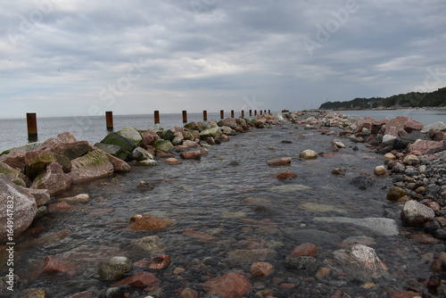 Wallpaper Mural Rocky shoreline with water flowing under cloudy sky   Torontodigital.ca