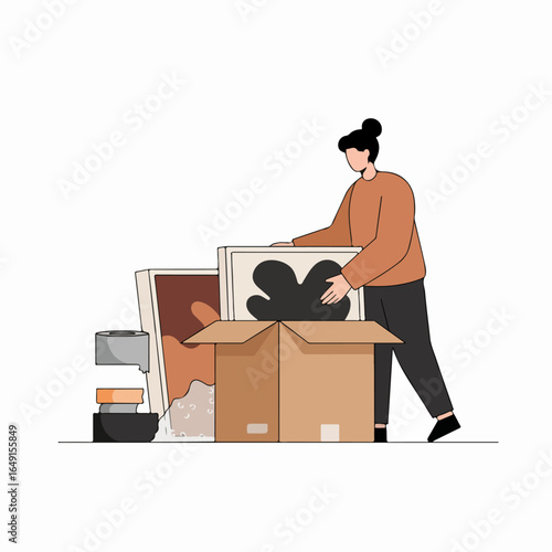 Woman packing artwork and belongings into a moving box, symbolizing relocation, storage, or home organization.