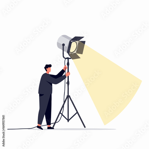 Professional male adjusting a powerful studio spotlight on a tripod, creating an intense light beam, symbolizing focus and attention.