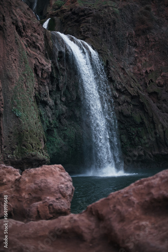 Mysterious night waterfall in Ouzoud, Morocco – dark landscape with green mossy rocks and misty atmosphere, magical nature scene in the Atlas Mountains
