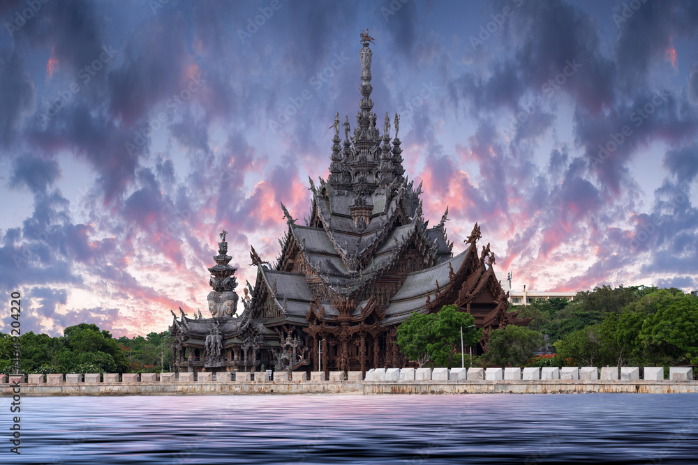 Naklejka premium Sanctuary of Truth temple construction on sunset in Pattaya, Thailand. The sanctuary is an all-wood building filled with sculptures based on traditional Buddhist and Hindu motifs.