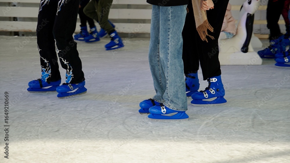 Fototapeta premium People ride on the skating rink on the ice rink during the Christmas holidays. Sports and fun pastime.