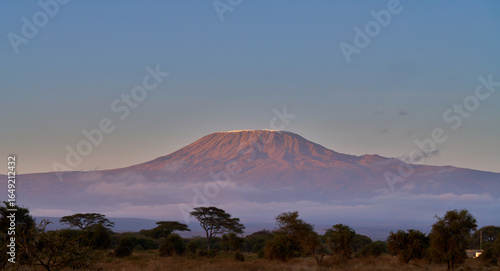 Sunlit Peak of Mount Kilimanjaro Rising Above Morning Clouds in Amboseli, Kenya