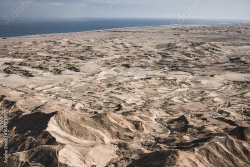 Desert landscape near Moçâmedes, Angola, with rugged mountains and the Atlantic Ocean in the distance