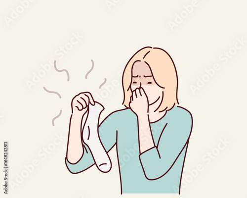 Disgusted young woman holding smelly socks covering nose. Hand drawn style vector design illustrations.