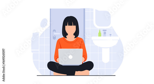 A young woman comfortably works on her laptop while sitting cross-legged on the floor in a modern, minimalist bathroom setting.