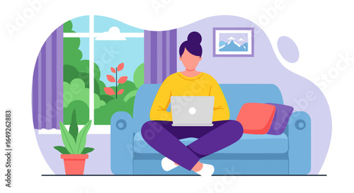 A woman comfortably works on her laptop while relaxing on a cozy sofa in a bright, sunlit room with plants.