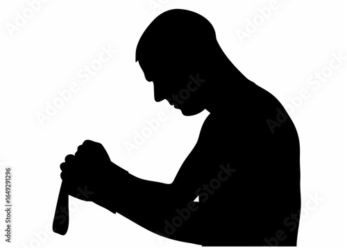 Silhouette of a man with head bowed holding a cane with both hands in a contemplative pose looking down