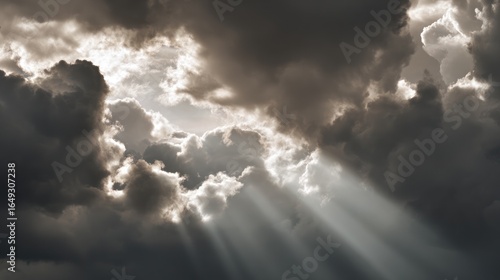 Dynamic sky with sun rays piercing through thick, grey clouds