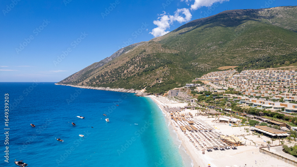 Naklejka premium Aerial view of beach clubs along the Himare Albanian Riviera coastline on the Ionian Sea in southern Albania beside vlore.