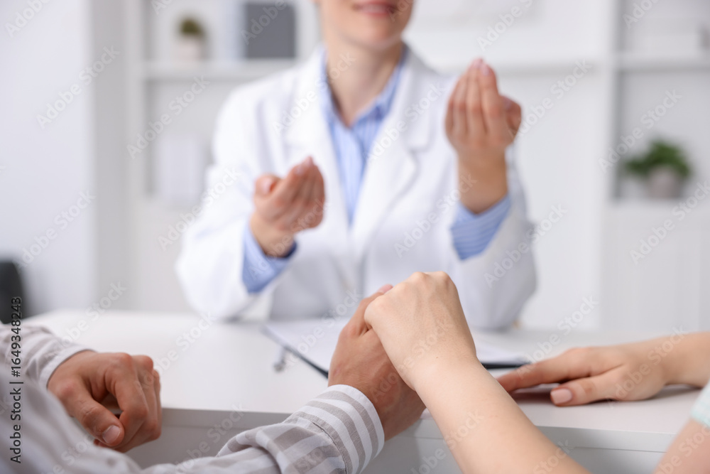 Obraz premium In vitro fertilization (IVF). Couple holding hands during appointment with doctor in reproductive clinic, closeup