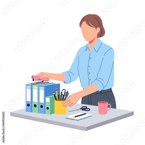 Faceless female office worker in a blue shirt stapling documents on binders at her desk.