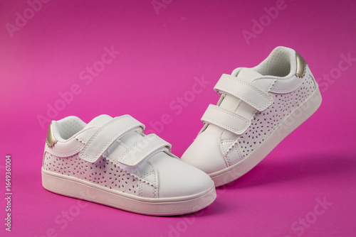 Foto Stylish white kids' sneakers with velcro straps  on pink background