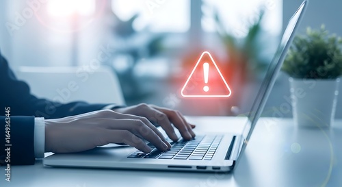 Close up of hands typing on laptop with red warning alert symbol and lens flare danger error