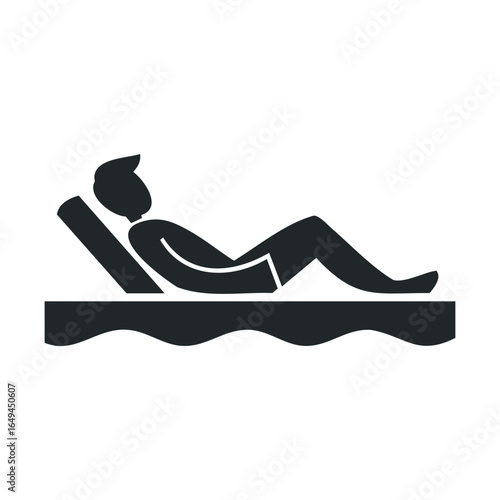 Silhouette of person relaxing on a sunbed by the water