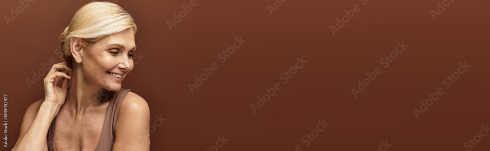 Fototapeta premium Senior woman with beautiful smile enjoying moments of serenity against a warm backdrop