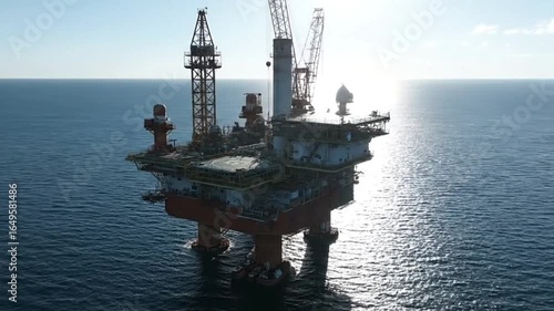 An offshore oil platform in a sea setting Features a crane support legs decks and industrial equipment