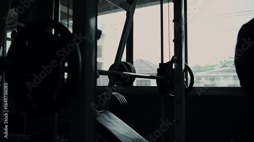 Fitness concept of 4k Resolution. Silhouette of male athlete training with a barbell in the gym.