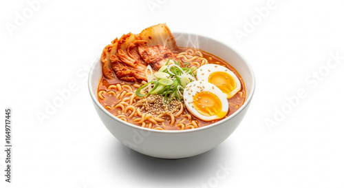 A delicious bowl of spicy ramen noodle soup with pork, kimchi, a soft-boiled egg, and scallions, isolated on a white background.